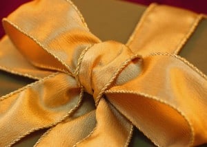 Appreciation Gifts of Thoughtfulness shown with a golden bow upon a gift wrapped in golden paper